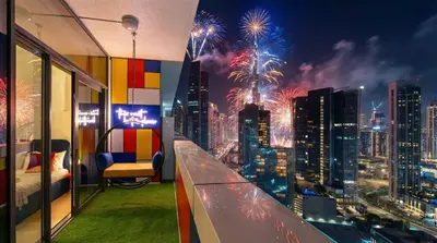 a room with a view of a city with fireworks at Modern High-Floor Apartment with Burj Khalifa View by Dejaview Stays in Dubai