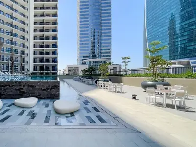 a patio with white tables and chairs and buildings at Modern High-Floor Apartment with Burj Khalifa View by Dejaview Stays in Dubai