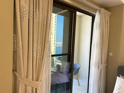 a room with a sliding glass door with a window at USMANS 3 Bedroom Apartment all Rooms Sea View Direct Beach Access Daily HOUSEKEEPING JBR in Dubai