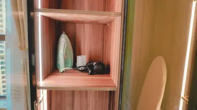 a wooden cabinet with a mirror and a surfboard in it at USMANS 3 Bedroom Apartment all Rooms Sea View Direct Beach Access Daily HOUSEKEEPING JBR in Dubai
