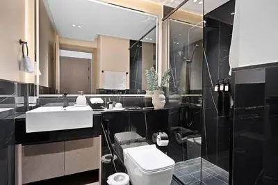 a bathroom with a white sink and a toilet at Binghatti Canal Business Bay in Dubai