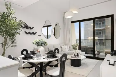 a white living room with a table and chairs at Binghatti Canal Business Bay in Dubai