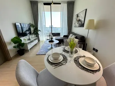 a living room with a white table and chairs at Elegant 1br Escape Jvc Pool & Balcony Access in Dubai