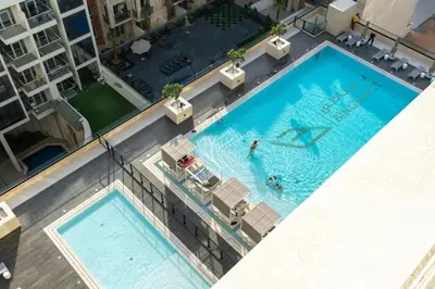 an overhead view of two swimming pools in a building at Modern Luxury Fully Furnished 1BH Apartment in Binghatt Emerald JVC - Easy Access to JBR, Circle Mall & Dubai Hills Mall in Dubai