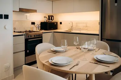 a wooden table with wine glasses on it in a kitchen at Private Beach & Canal View-Top Location-Pool-Gym in Dubai