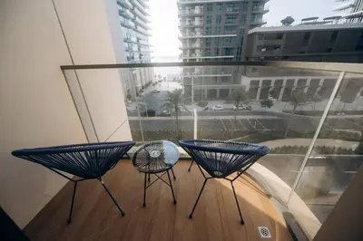 a balcony with two chairs and a large window at Private Beach & Canal View-Top Location-Pool-Gym in Dubai