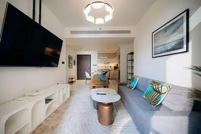 a living room with a couch and a large tv at Private Beach & Canal View-Top Location-Pool-Gym in Dubai
