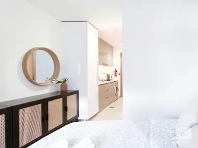 a white bedroom with a mirror and a bed at Meydan Bliss Luxurious Studio with Private Balcony in Dubai