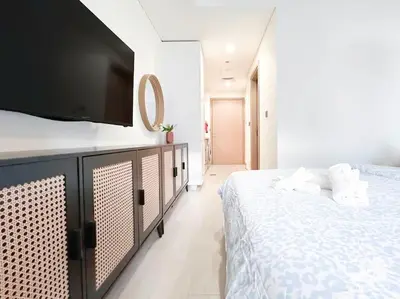 a bedroom with a bed and a flat screen tv at Meydan Bliss Luxurious Studio with Private Balcony in Dubai