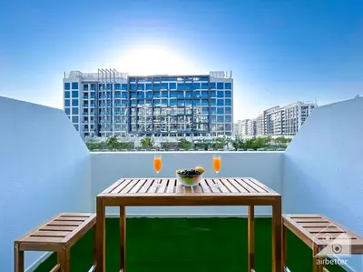 a table and two chairs on a balcony with a building at Meydan Bliss Luxurious Studio with Private Balcony in Dubai