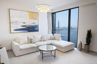 a living room with a white couch and a table at Luxurious 3BR - Pool - Canal View - Kids Play Area in Dubai