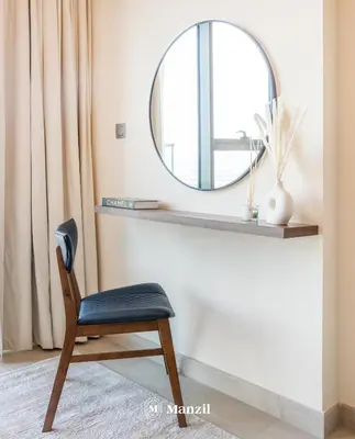 a mirror sitting on a shelf next to a chair at Manzil - 1BR Apartment in Farhad Aziz Residence with Burj View in Dubai
