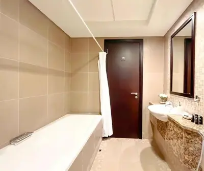 a bathroom with a tub and a sink and a mirror at Stunning 2 bedrooms in Sky Gardens DIFC in Dubai