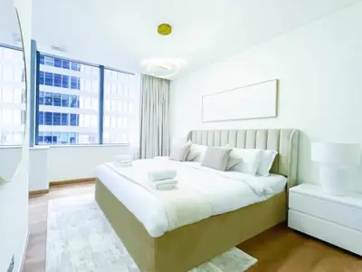 a white bedroom with a large bed and a window at Stunning 2 bedrooms in Sky Gardens DIFC in Dubai