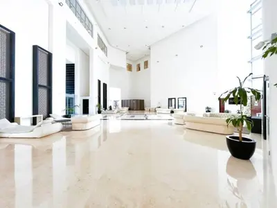 a large living room with white furniture and a potted plant at Stunning 2 bedrooms in Sky Gardens DIFC in Dubai