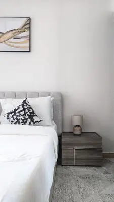 a bedroom with a bed and a table with a lamp at Modern Luxury Fully Furnished 1BH Apartment in Binghatt Heights JVC - Easy Access to JBR, Circle Mall & Dubai Hills Mall in Dubai