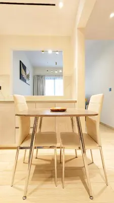 a dining room with a wooden table and chairs at Modern Luxury Fully Furnished 1BH Apartment in Binghatt Heights JVC - Easy Access to JBR, Circle Mall & Dubai Hills Mall in Dubai