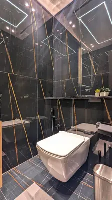 a bathroom with a white toilet and a black wall at Modern Luxury Fully Furnished 1BH Apartment in Binghatt Heights JVC - Easy Access to JBR, Circle Mall & Dubai Hills Mall in Dubai