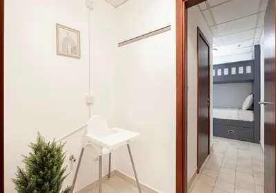 a hallway with a white sink and a bedroom at 2 min walk to JBR Beach & Dubai Marina - Sea View in Dubai