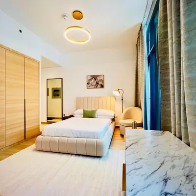 a bedroom with a king sized bed and a table at Cozy Studio JVC Dubai, Short Drive to Dubai Marina, JBR, Downtown Dubai in Dubai