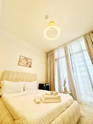 a bedroom with a large bed with a large window at Cozy Studio JVC Dubai, Short Drive to Dubai Marina, JBR, Downtown Dubai in Dubai
