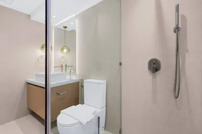 a bathroom with a shower and a toilet and a sink at FIRST CLASS 1BR Modern Downtown Oasis in Dubai