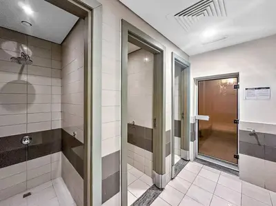 a bathroom with a walk in shower and a glass door at FIRST CLASS 1BR Modern Downtown Oasis in Dubai