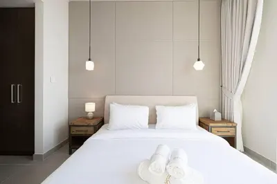 a bedroom with a white bed with towels on it at 2Bed-400m from Burj Khalifa- Heart of Dubai in Dubai