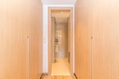 a hallway with wooden walls and a hallway leading to a bathroom at Luxury Apartment in Oakley Square Residences, JVC in Dubai