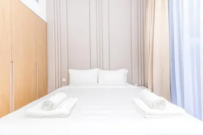 a white bed with two white towels on it at Luxury Apartment in Oakley Square Residences, JVC in Dubai
