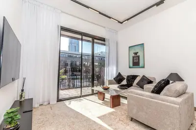 a living room with a couch and a large window at Luxury Apartment in Oakley Square Residences, JVC in Dubai