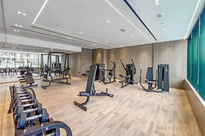 a gym with several treadmills and exercise bikes at 1BR Gem in JVC Pool, Gym, BBQ & Balcony in Dubai