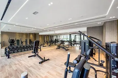 a gym with treadmills and exercise bikes in it at 1BR Gem in JVC Pool, Gym, BBQ & Balcony in Dubai