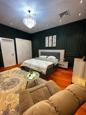 a bedroom with a bed and a couch and a table at Lavender 2 jvc in Dubai