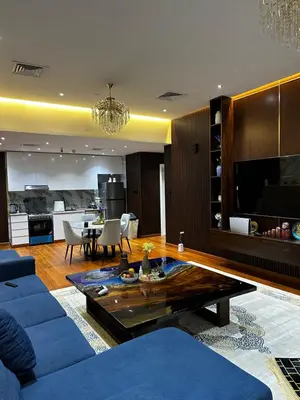 a living room with a blue couch and a table at Lavender 2 jvc in Dubai