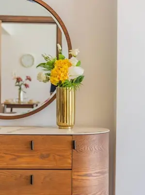 a vase of flowers on a dresser in front of a mirror at Elegant One Bed Apartment - Hameni Tower,JVC in Dubai