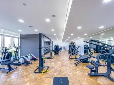 a gym with several treadmills and exercise bikes at Elegant One Bed Apartment - Hameni Tower,JVC in Dubai