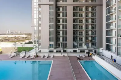 a large building with a swimming pool in front of a building at Locations I Creek Vistas Reserve I Luxury Calm 1BR I 12 Min Drive to Downtown Dubai & Business Bay I Modern Comfort in Meydan Community in Dubai