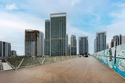 a bridge over a city with tall buildings at Vida Creek Beach 1 Bedroom in Dubai