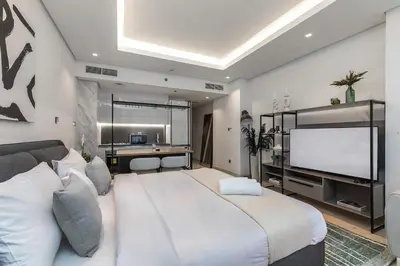 a bedroom with a large bed and a flat screen tv at Studio Sterling BusinessBay in Dubai