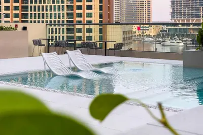 two white chairs sitting in a pool on a building at Studio Sterling BusinessBay in Dubai