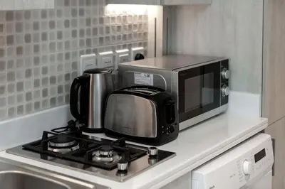 a microwave sitting on top of a kitchen stove at Modern Studio in Seven Palm in Dubai