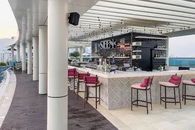a bar with pink stools in a building at Modern Studio in Seven Palm in Dubai