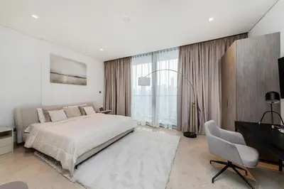 a bedroom with a bed and a desk and a television at Burj Khalifa View 3bedroom in Dubai