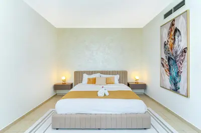a bedroom with a large bed with two lamps at Savis Homes - Luxury 2 Bedroom Suite with Full Burj Khalifa View in Dubai