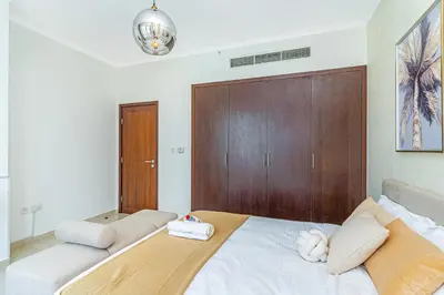 a bedroom with a large bed with a wooden headboard at Savis Homes - Luxury 2 Bedroom Suite with Full Burj Khalifa View in Dubai