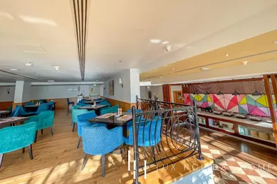 a restaurant with blue chairs and tables at LUX The Majara Marina View Suite in Dubai
