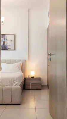 a bedroom with a bed and a table with a lamp at Fully Furnished 1BR In Montrose Tower B Dubai, Close by Dubai Science Park, Dubai Miracle Garden, Dubai Hills Mall in Dubai