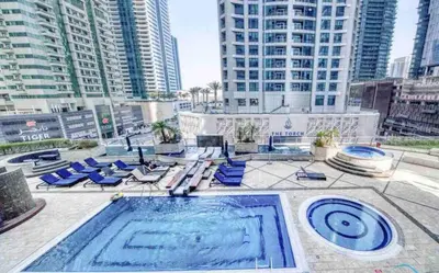 a swimming pool with blue lounge chairs and buildings at Skyline Sanctuary on the 82nd in Dubai
