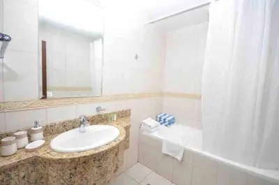 a bathroom with a sink and a mirror and a tub at Skyline Sanctuary on the 82nd in Dubai